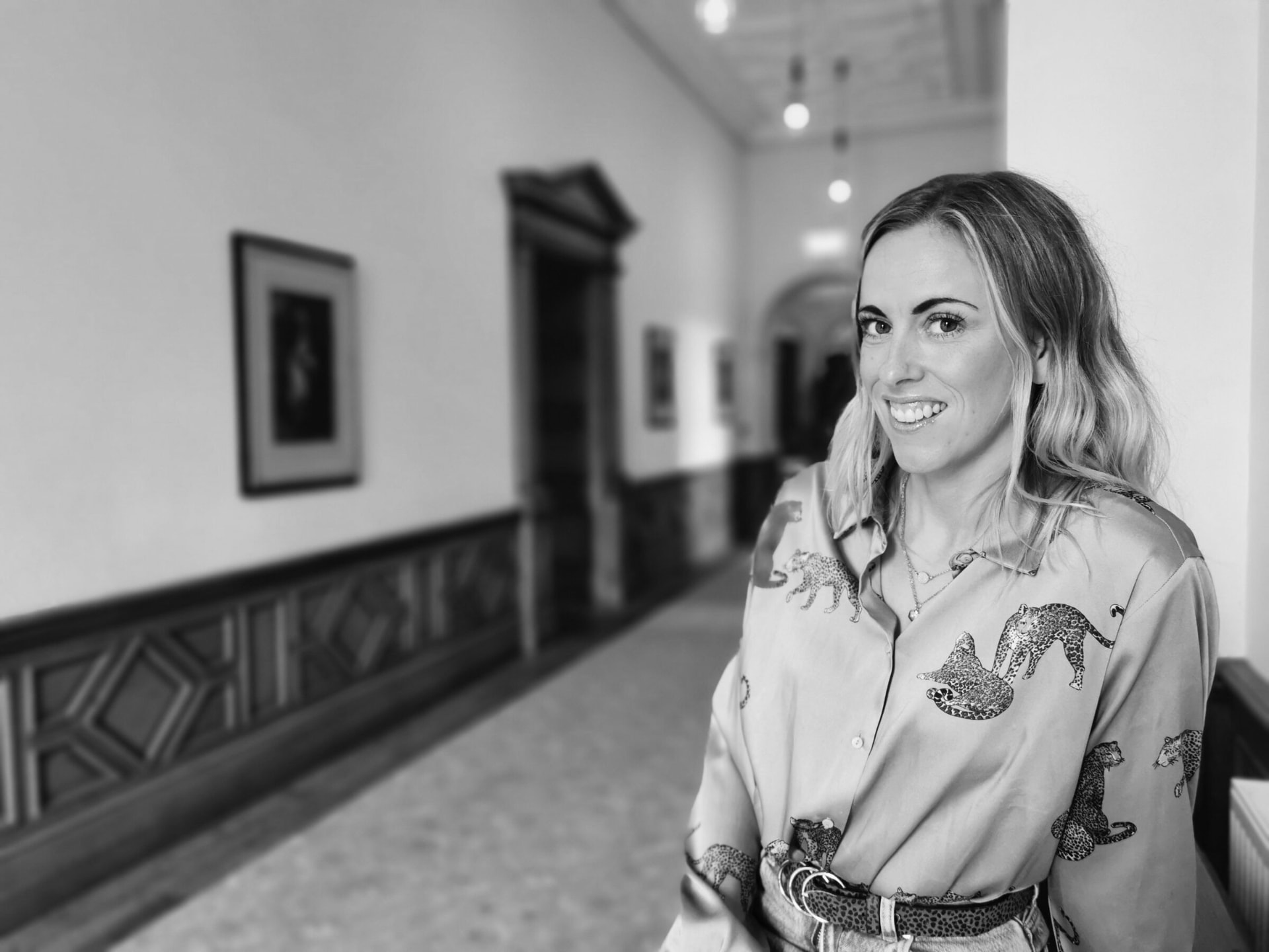 Claire Grigson smiling in a long corridor