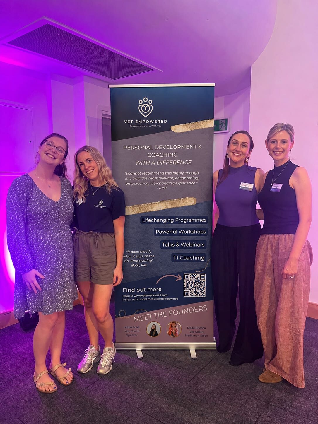 The Vet Empowered coaching team together in front of a Vet Empowered banner
