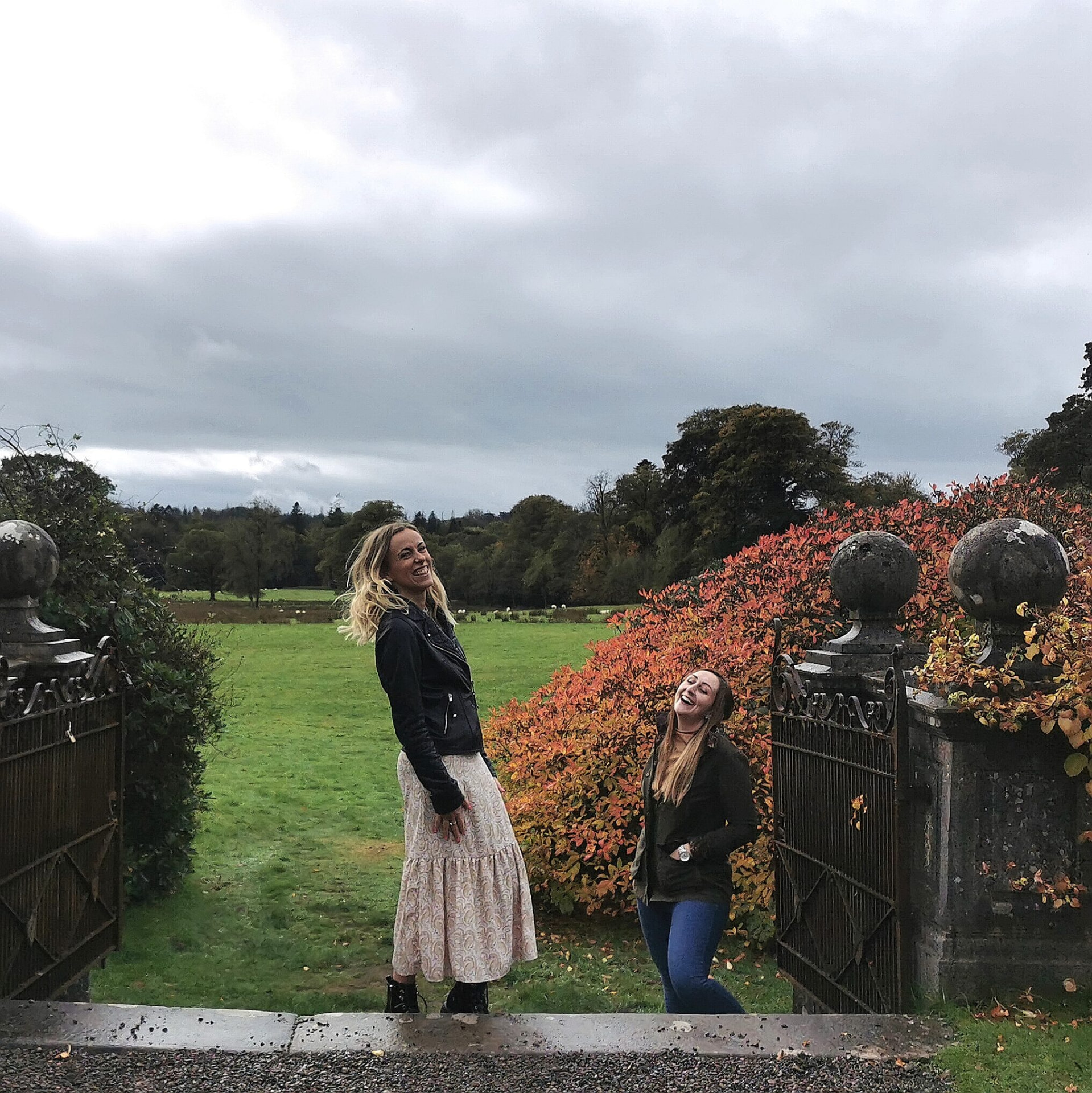 Katie Ford and Claire Grigson laughing by a set of old garden gates