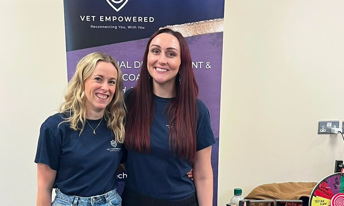 Claire Grigson and Katie Ford, founders of Vet Empowered, smiling in front of a Vet Empowered banner