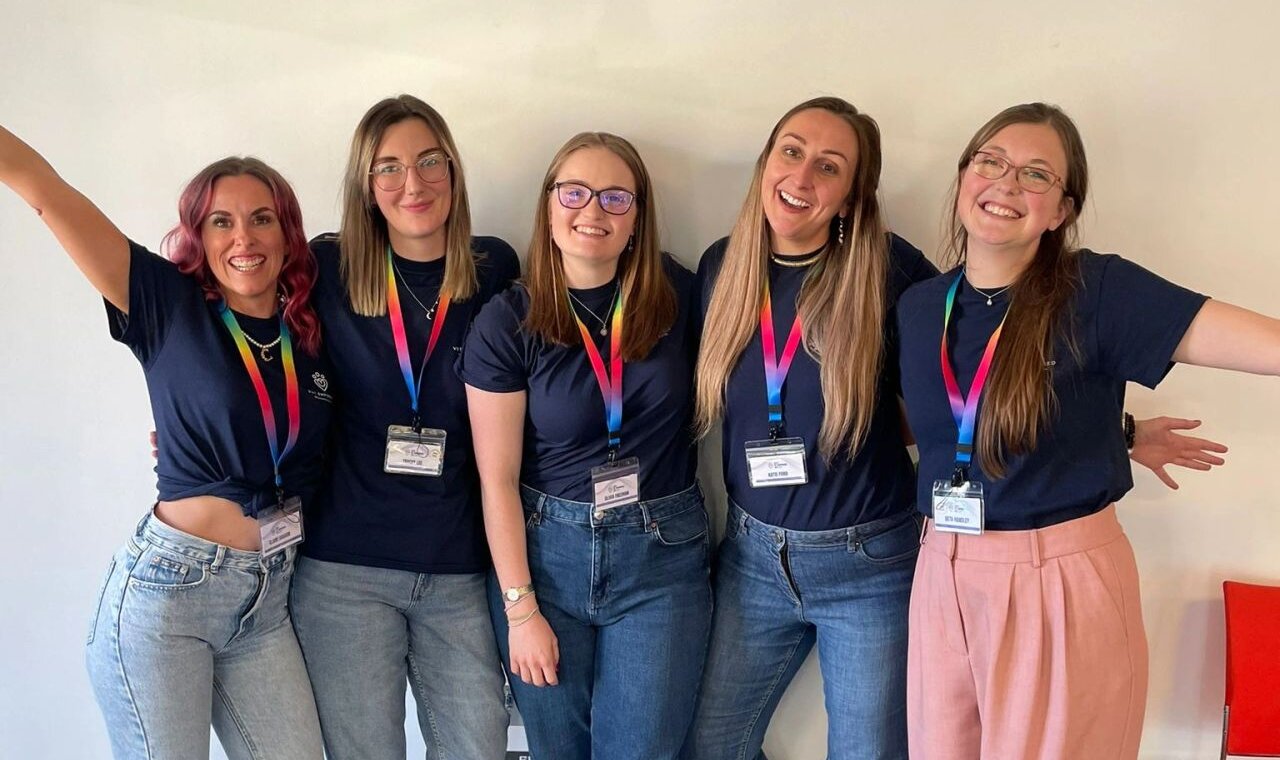 The Vet Empowered team together in Vet Empowered T-shirts and rainbow lanyards