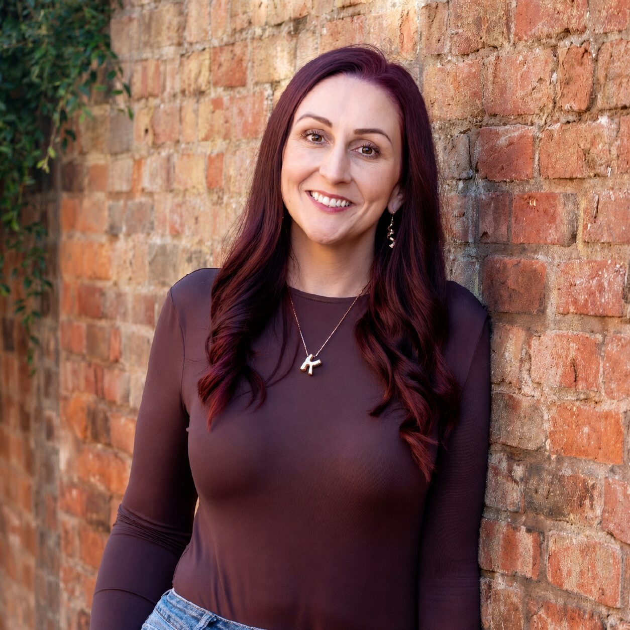 Dr Katie Ford, smiling against a brick wall